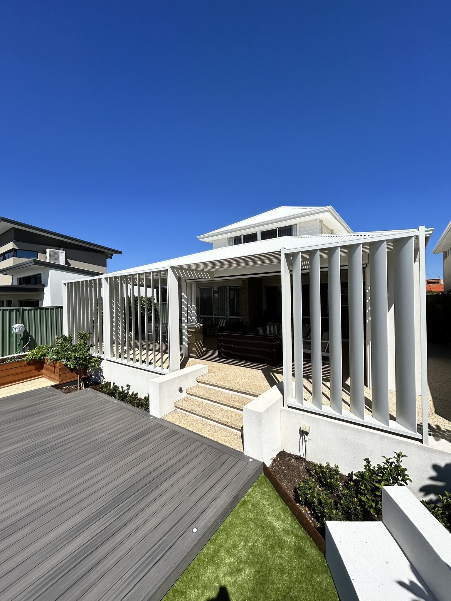 White aluminium arbour with vertical privacy screens