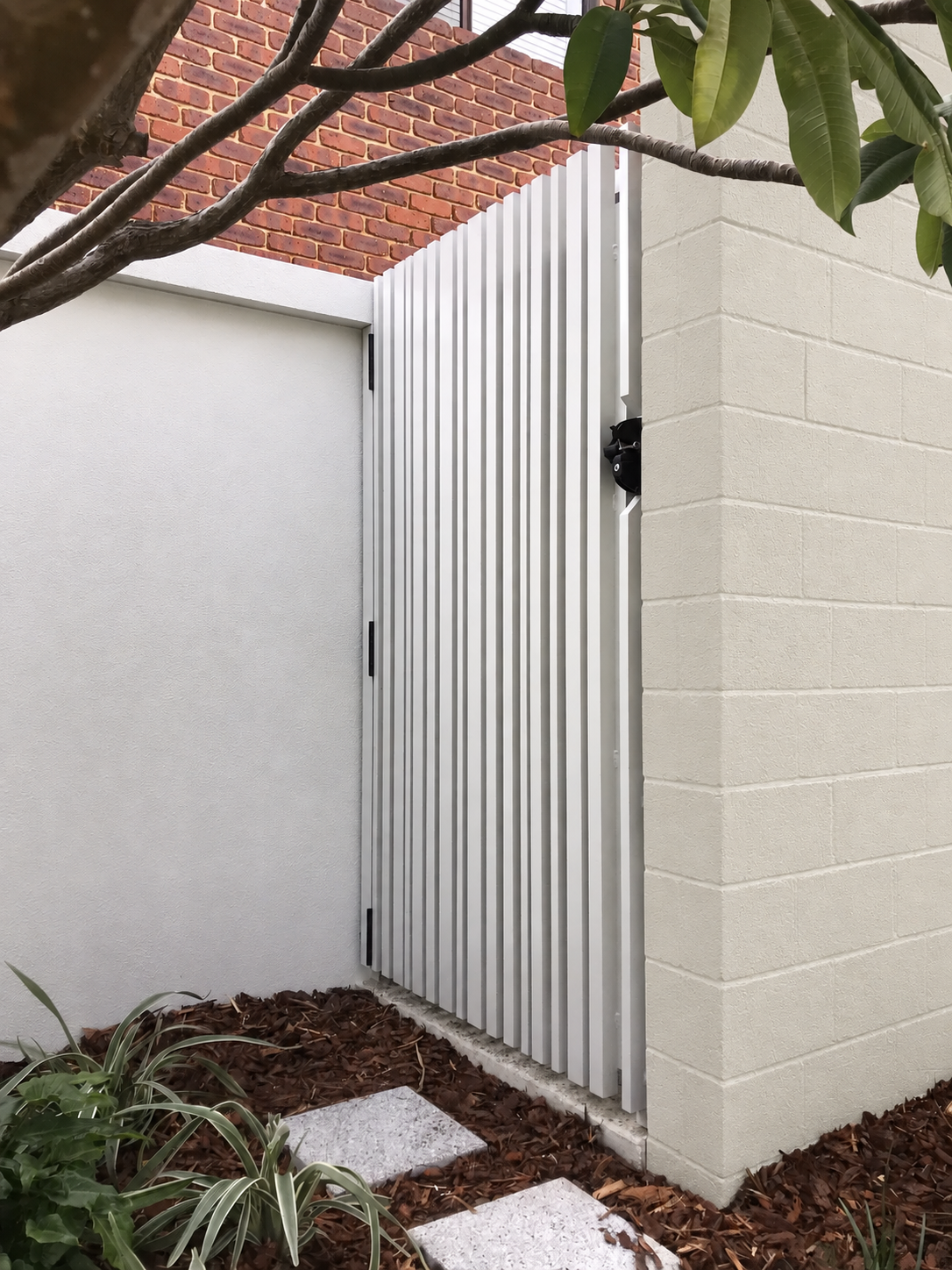 White vertical-batten pedestrian gate beside a Surfmist-coloured wall